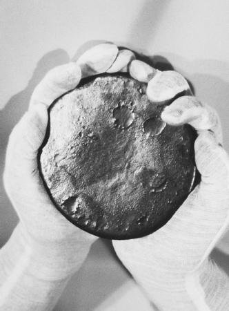 GLOVED HANDS HOLD A GRAY LUMP OF URANIUM. THIS MATERIAL HAS BEEN REMOLDED AFTER HAVING BEEN REMOVED FROM A TITAN II MISSILE, PART OF THE DISARMAMENT AFTER THE END OF THE COLD WAR. (Martin Marietta; Roger Ressmeyer/Corbis. Reproduced by permission.)