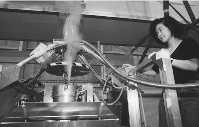 A RESEARCHER WORKS WITH LIQUID HELIUM AS PART OF AN EXPERIMENT ON COSMIC BACKGROUND RADIATION. CLOSE TO ABSOLUTE ZERO, HELIUM TRANSFORMS INTO A HIGHLY UNUSUAL LIQUID THAT HAS NO MEASURABLE RESISTANCE TO FLOW. (Roger Ressmeyer/Corbis. Reproduced by permission.)