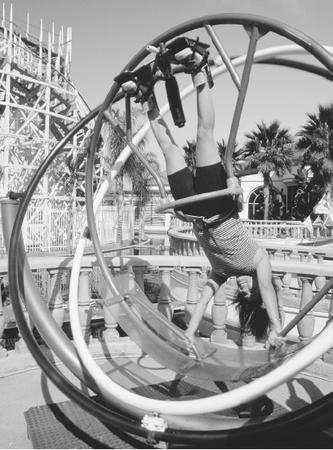 TORQUE, ALONG WITH ANGULAR MOMENTUM, IS THE LEADING FACTOR DICTATING THE MOTION OF A GYROSCOPE. HERE, A WOMAN RIDES INSIDE A GIANT GYROSCOPE AT AN AMUSEMENT PARK. (Photograph by Richard Cummins/Corbis. Reproduced by permission.)