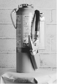 A FIRE EXTINGUISHER CONTAINS A HIGH-PRESSURE MIXTURE OF WATER AND CARBON DIOXIDE THAT RUSHES OUT OF THE SIPHON TUBE, WHICH IS OPENED WHEN THE RELEASE VALVE IS DEPRESSED. (Photograph by Craig Lovell/Corbis. Reproduced by permission.)