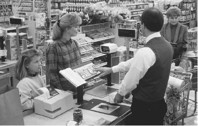 THE CHECKOUT SCANNERS IN GROCERY STORES USE HOLOGRAPHIC TECHNOLOGY THAT CAN READ A UNIVERSAL PRODUCT CODE (UPC) FROM ANY ANGLE. (Photograph by Bob Rowan; Progressive Image/Corbis. Reproduced by permission.)
