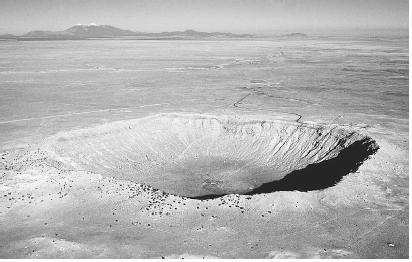 METEOR CRATER, ARIZONA. MOST NOTABLE AMONG CATASTROPHE THEORIES OF EARTH'S FORMATION IS THE COLLISION OF METEORITES. (© Francois Gohier/Photo Researchers. Reproduced by permission.)