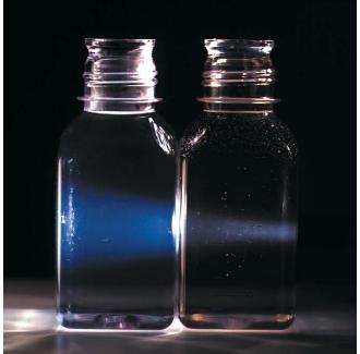 Light shining through a solution of sodium hydroxide (left) and a colloidal mixture. The size of colloidal particles makes the mixture, which is neither a solution nor a suspension, appear cloudy. (Reproduced by permission of Photo Researchers, Inc.)
