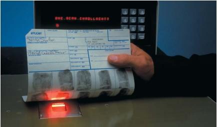 Fingerprints being recorded onto an electronic tracking system. (Reproduced by permission of Phototake.)