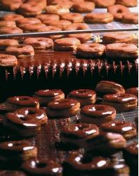 The mass production of chocolate-covered doughnuts. (Reproduced by permission of The Stock Market.)