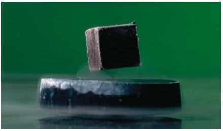 A small cube magnet hovering over a nitrogen-cooled specimen of a superconducting ceramic demonstrates the Meissner effect. Because the test is so distinctive it is used as a test for identifying superconducting materials. (Reproduced by permission of Phototake.)