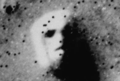 Aerial photograph of a Martian mesa that resembles a human face. PHOTOGRAPH REPRODUCED BY PERMISSION OF THE CORBIS CORPORATION.