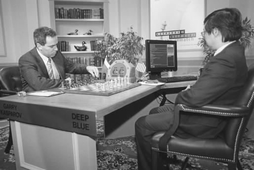 Chess champion Gary Kasparov executes a move during a 1997 match against the highly sophisticated computer Deep Blue as the computers designer watches.