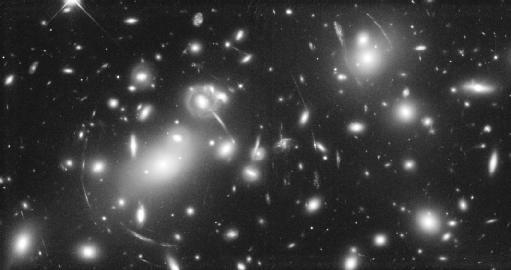 This photo taken by the Hubble Space Telescope shows a cluster of distant galaxies whose combined gravity distorts and bends the light these objects give off.