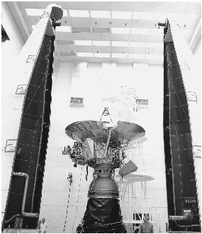 Pioneer 11 rests between the two halves of the nose cone of the rocket that will blast it into space.