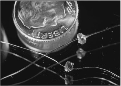 These tiny diamond dies used in telephone lines have been drilled with laser beams. Such small holes could not be cut in diamonds without lasers.