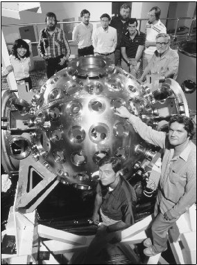 American researchers stand beside a high-energy laser designed for mounting on a satellite, part of the Star Wars weapons program.