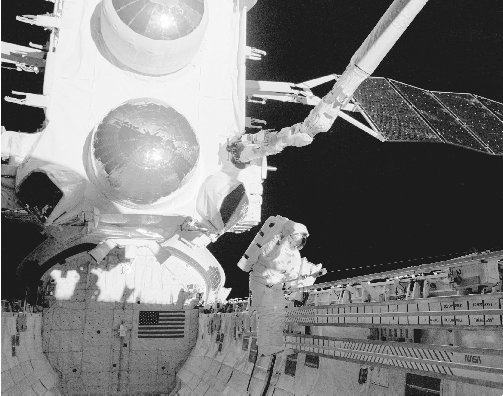In 1991 an astronaut in the payload bay of the space shuttle Atlantis prepares the Compton Gamma Ray Observatory, a powerful gamma ray telescope, for launch.
